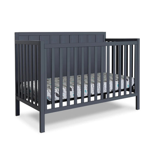 Navy crib with a mattress and bedding on a white background