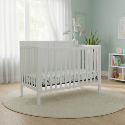 White crib with a white mattress on a white background