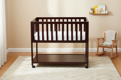 Wooden crib with a mattress on a white background