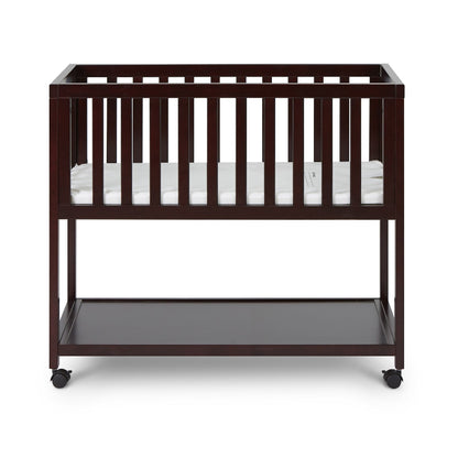 Wooden crib with a mattress on a white background