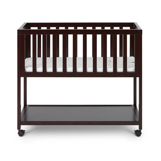 Wooden crib with a mattress on a white background