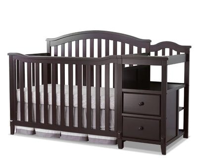 Dark wood crib with changing table on a white background