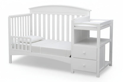 Gray crib with attached changing table on a white background
