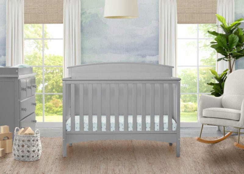 Nursery room with a gray crib, dresser, and rocking chair.