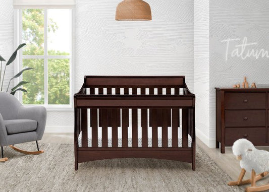 Nursery room with a wooden crib, gray chair, and dresser.
