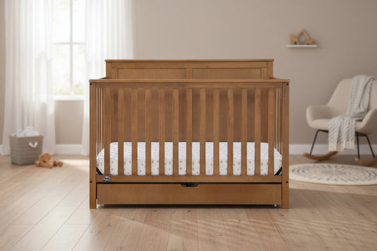 Wooden crib with a white mattress on a white background