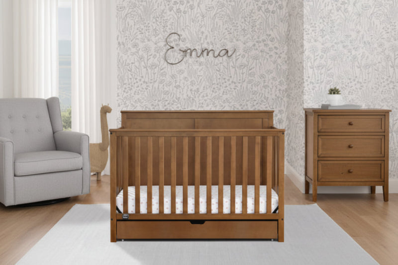 Wooden crib in a room with a decorative wall and furniture.