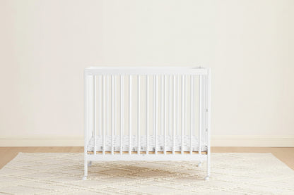 White radiator on a light wooden floor with a white wall background