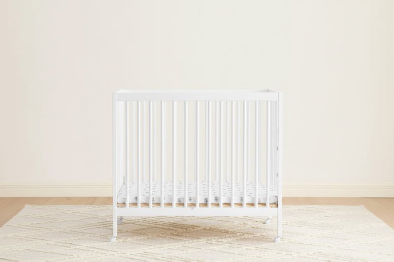 White radiator on a light wooden floor with a white wall background