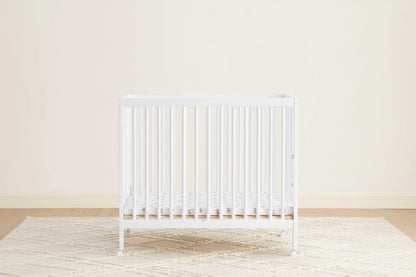 White radiator on a light wooden floor with a white wall background