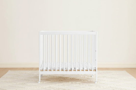 White radiator on a light wooden floor with a white wall background