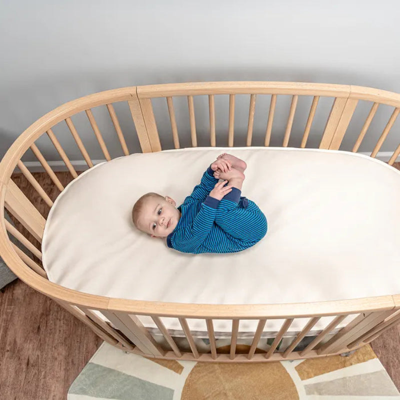 Firm and supportive oval baby crib mattress made with certified organic materials