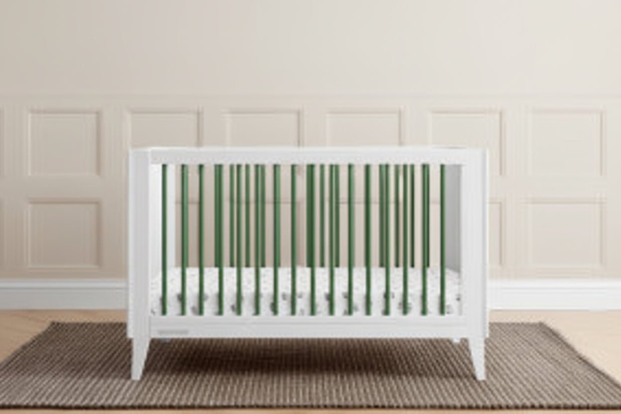 White crib in a room with green paneling