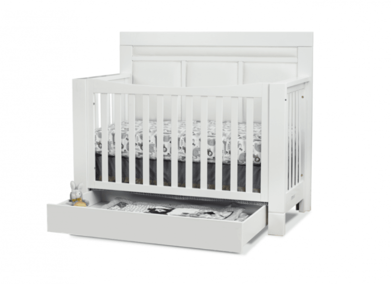 White crib with a visible drawer on a white background