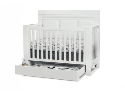 White crib with a visible drawer on a white background