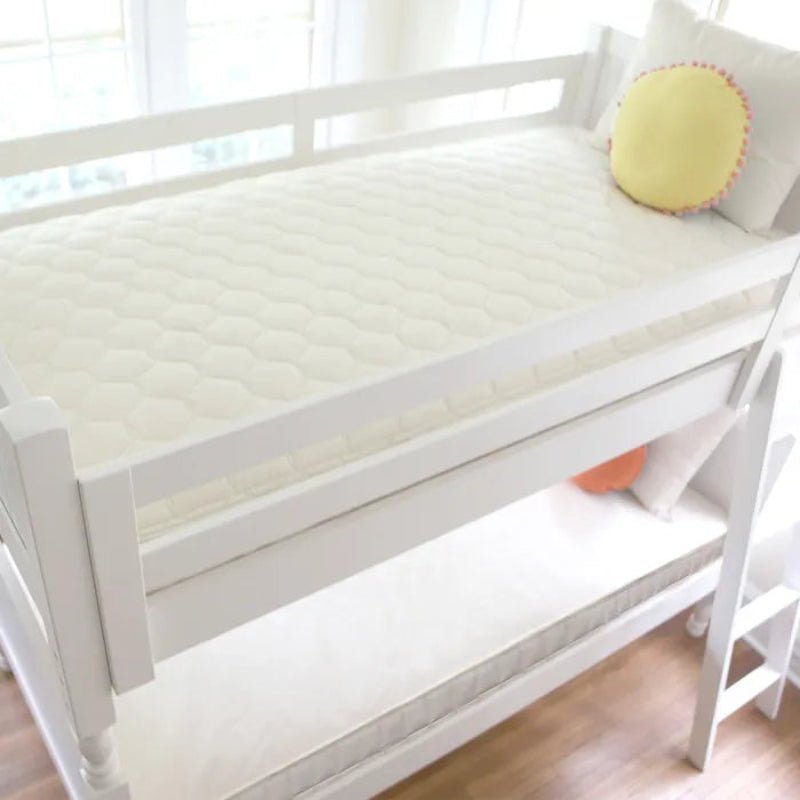 White bed with a yellow pillow in a bright room