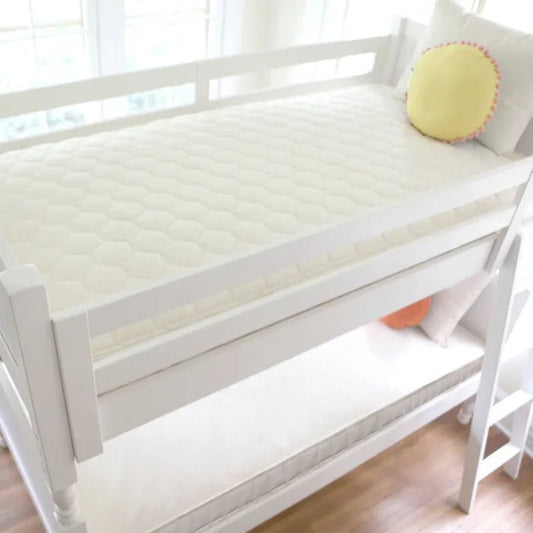 White bed with a yellow pillow in a bright room
