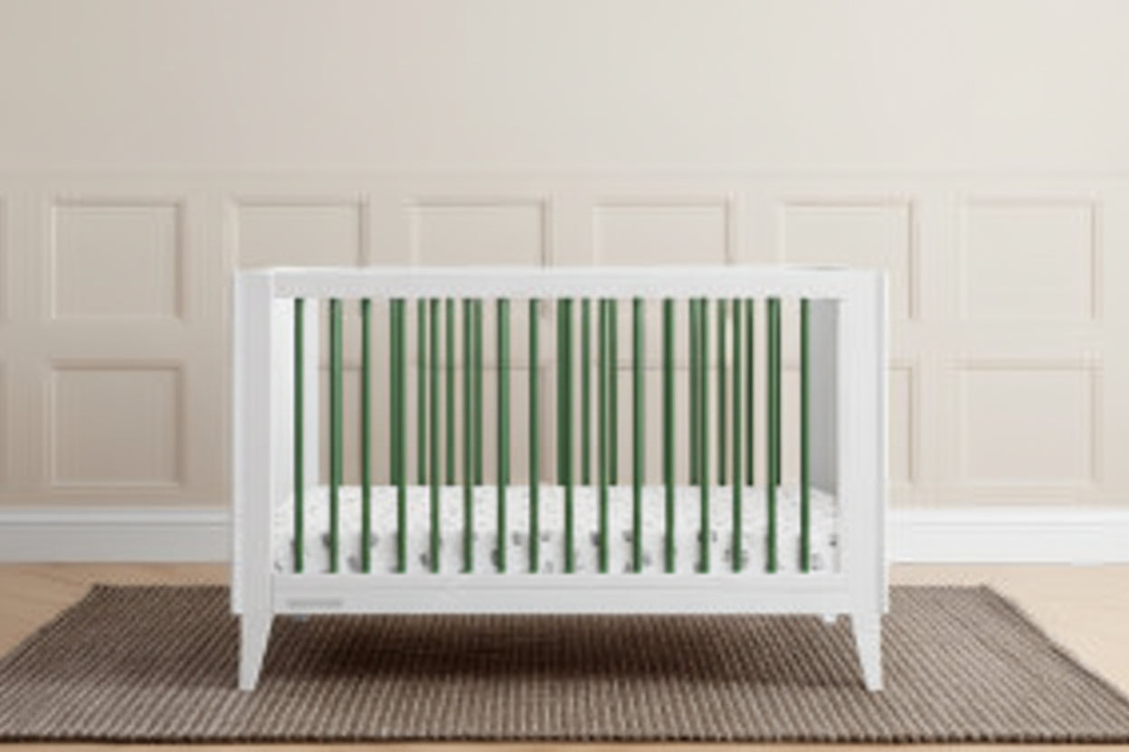 White crib in a room with green paneling