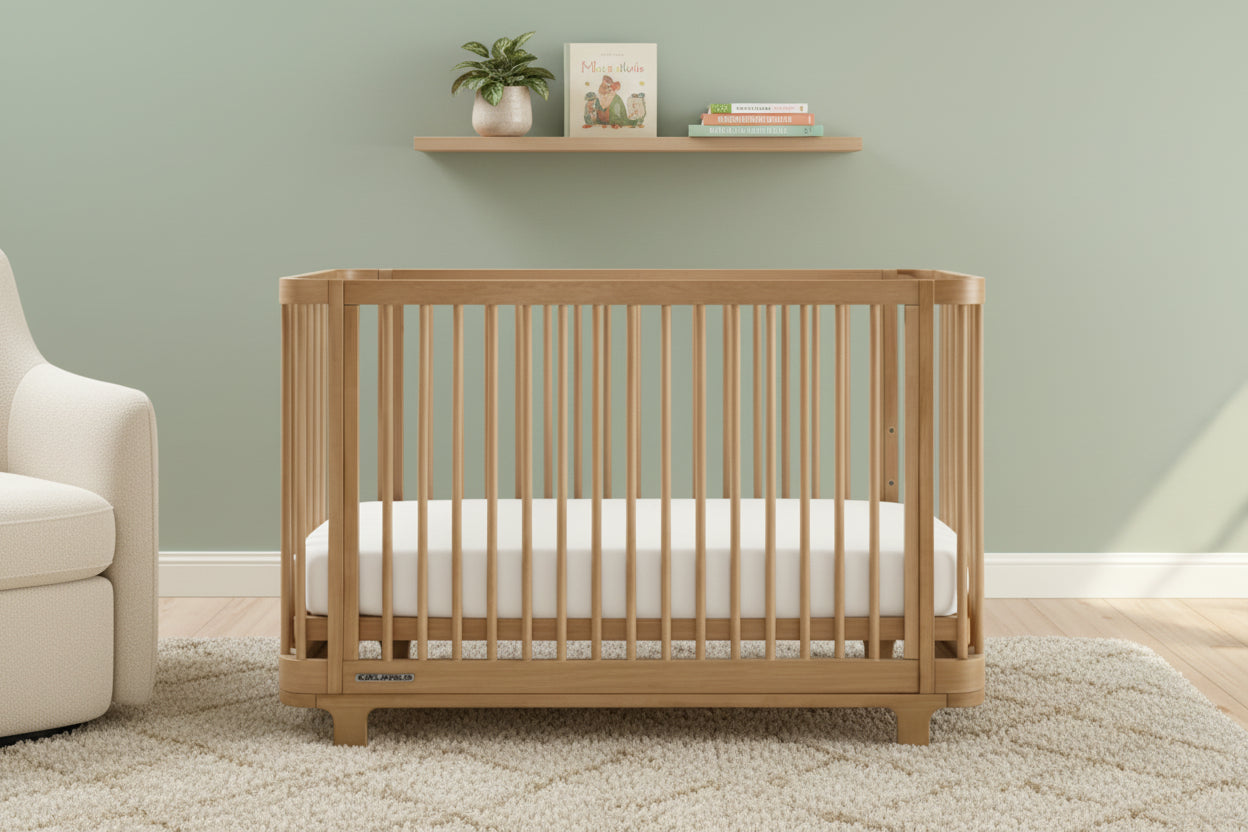 Wooden crib with a white mattress on a plain background